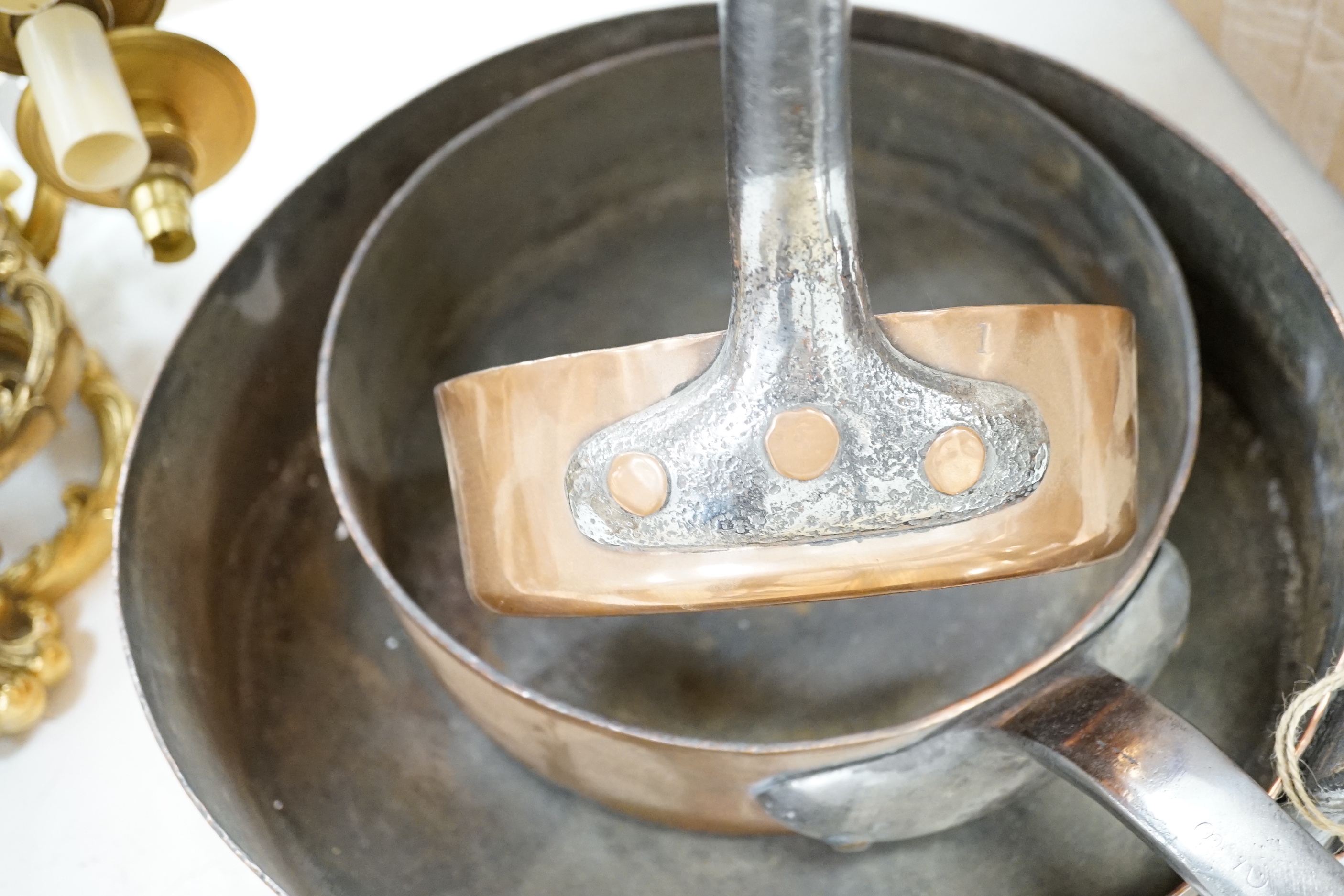 Three copper pans, largest diameter 35cm